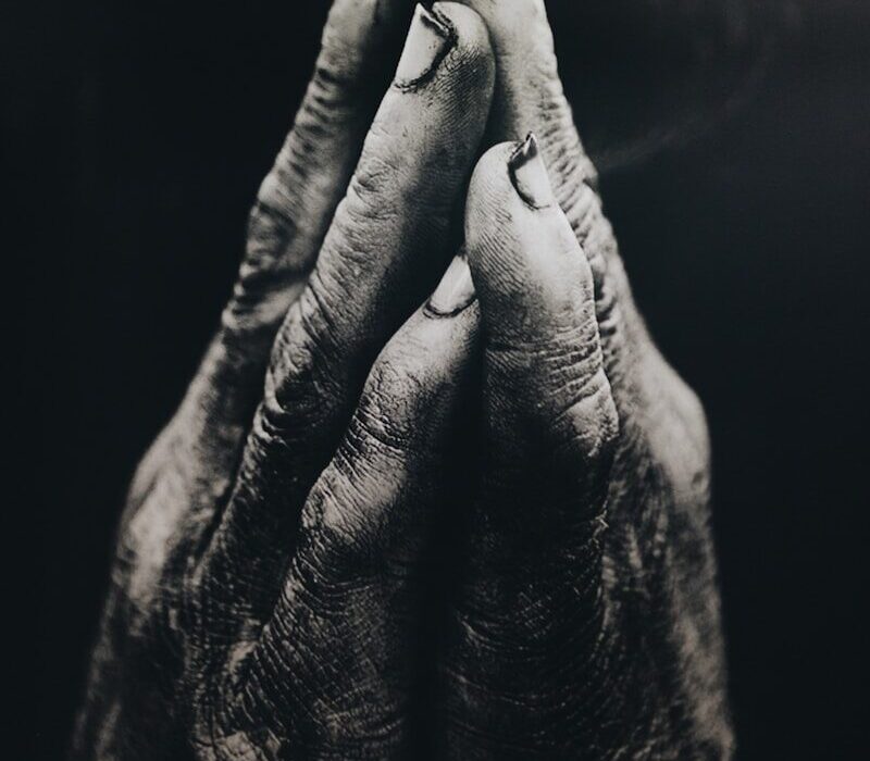 grayscale photography of praying hands